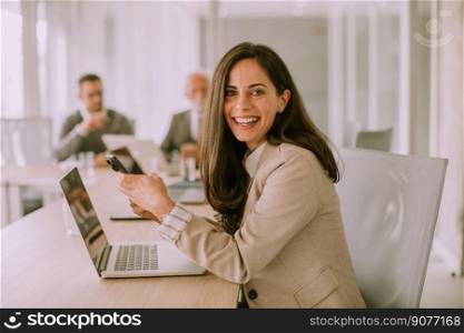 Pretty young woman using mobile phone in the office