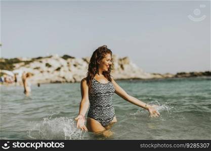 Pretty young woman walking in the sea on a summer vacation