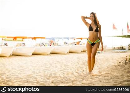 Pretty young woman walking on the beach at summer
