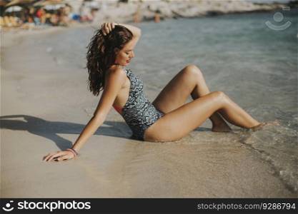 Pretty young woman wearing bikini relaxing on the seashore at summer holiday