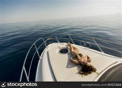 Pretty young woman wears bikini on the yacht at summer
