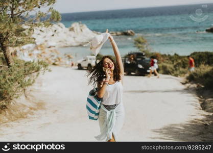 Pretty young woman with a bag on the beach at sunny∑mer day