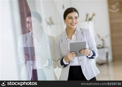 Pretty young woman with a digital tablet in the modern office
