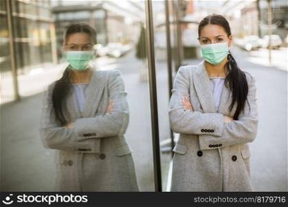 Pretty young woman with a protective facial mask on the street
