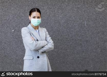 Pretty young woman with a protective facial mask on the street