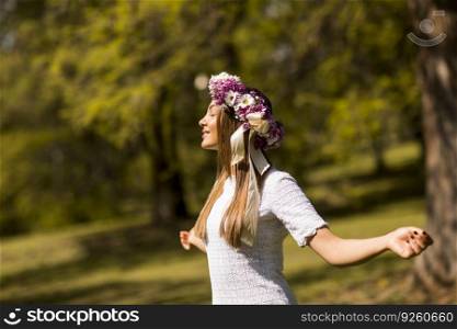 Pretty young woman with flowers in her hair on sunny spring day