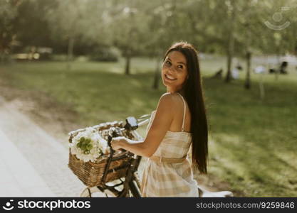 Pretty young woman with flowers in the basket of electric bike