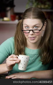 Pretty young woman with glasses and small coffee cup