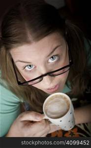 Pretty young woman with glasses and small coffee cup