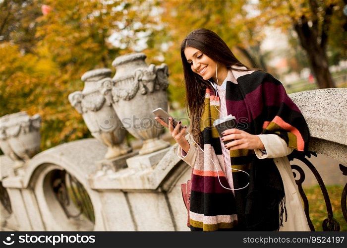 Pretty young woman with mobile phone and coffee cup