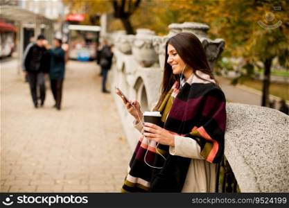Pretty young woman with mobile phone and coffee cup