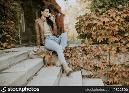 Pretty young woman with mobile phone on autumn day