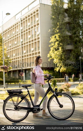 Pretty young woman with modern city electric e-bike clean sustainable urban transportation