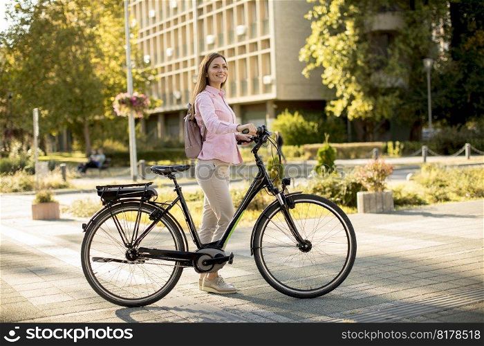 Pretty young woman with modern city electric e-bike clean sustainable urban transportation