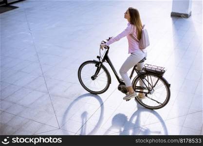 Pretty young woman with modern city electric e-bike clean sustainable urban transportation