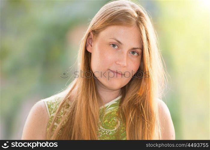 Pretty young woman with red long hair posing over a window