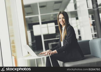 Pretty young woman working on laptop in the office