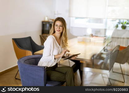 Pretty young woman working with digital tablet in the office