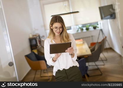 Pretty young woman working with digital tablet in the office