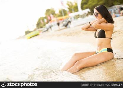 Pretty young woman woth singlasses on the beach at summer