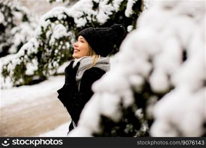 Pretty young womani n warm clothes enjoying in snow