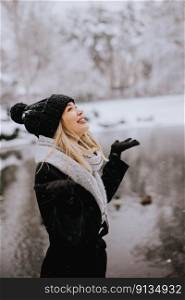 Pretty young womani n warm clothes enjoying in snow