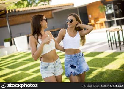 Pretty young women posing in courtyard at hot summer day