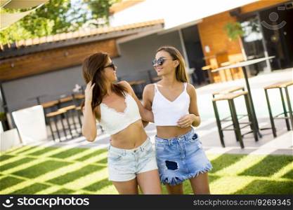 Pretty young women posing in courtyard at hot summer day