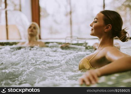 Pretty young women relaxing in the whirlpool bathtub at the poolside