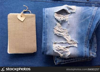 Price tag label at jeans background texture. Blue jeans denim fabric on table