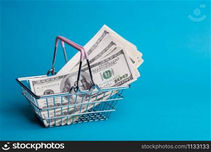 Prices for shopping consumer basket products. empty basket on a blue background full of dollars
