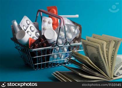 Prices for shopping consumer basket products with medicines and a bundle of dollars on a blue background. expensive treatment