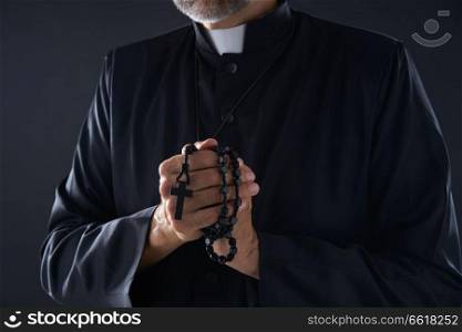 Priest praying hands with rosary beads male