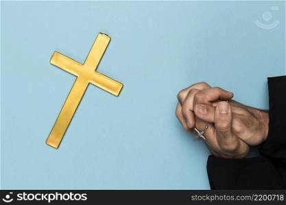 priest praying with wood cross