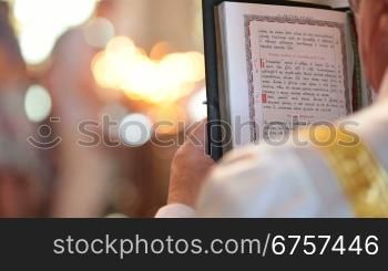 Priest reading the Bible in church