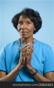 Prime adult female African American portrait with hands in prayer position.