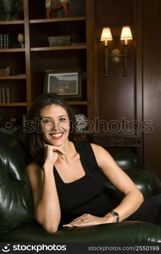 Prime adult Hispanic female sitting looking at viewer smiling.