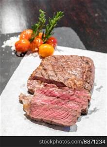 Prime tenderloin beef steak served with grilled tomato with sea salt