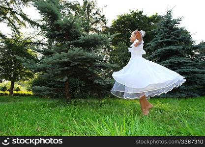 princess girl in white dress dances on lawn
