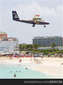 PRINCESS JULIANA AIRPORT, ST MAARTEN - July 19, 2013: Airplane lands over Maho beach on July 19, 2013. The 2300m runway is approached over the sea. ST MAARTEN, July 19, 2013