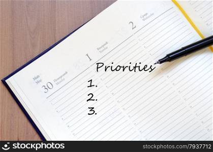 Priorities Concept In Yellow Blank Notepad On Office Wooden Table