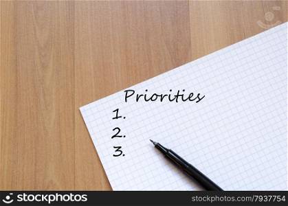 Priorities Concept White Blank Notepad On Office Wooden Table
