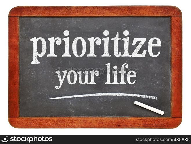 Prioritize your life advice - white chalk text on a isolated vintage slate blackboard. blackboard