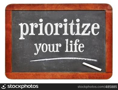 Prioritize your life advice - white chalk text on a isolated vintage slate blackboard. blackboard