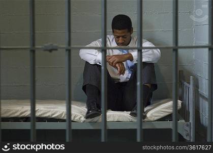 Prisoner sitting in his prison cell
