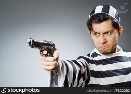 Prisoner with gun against dark background