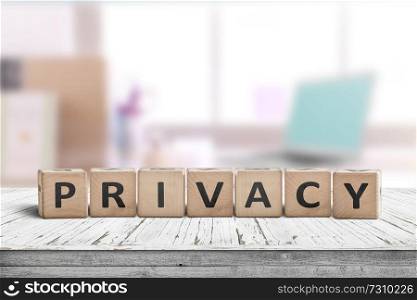 Privacy sign on a wooden table in a bright room with a computer