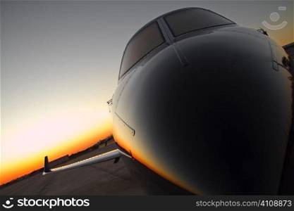 Private jet on runway at sunset
