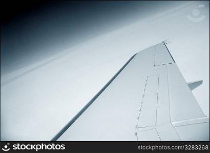 Private jet wing above the clouds.