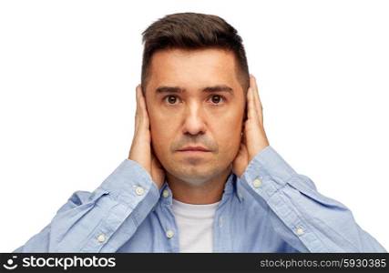 problem, emotion, stress, hearing problem and people concept - face of middle aged latin man covering his ears with hand palms
